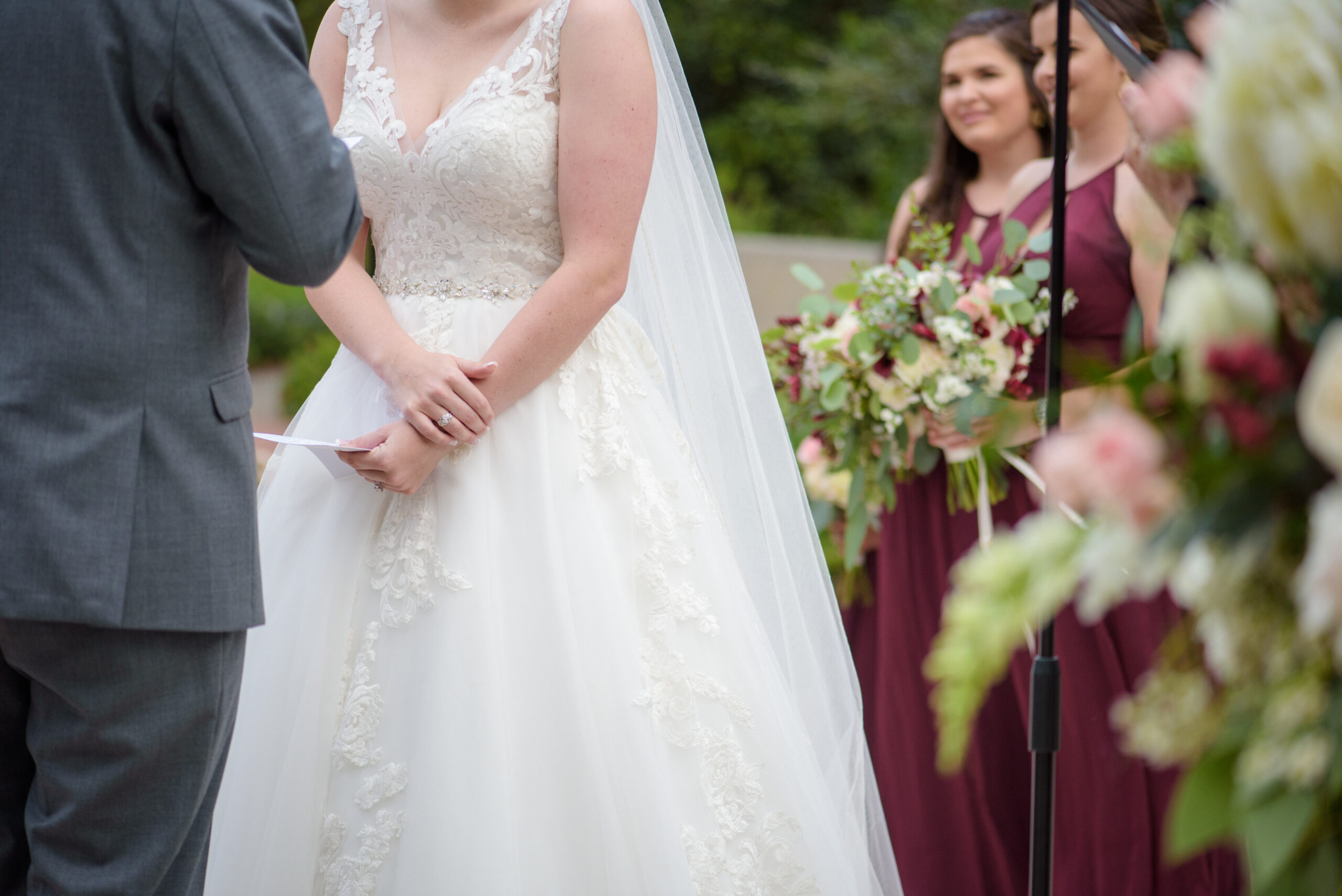 bride holding vows in her hand at the wedding alter