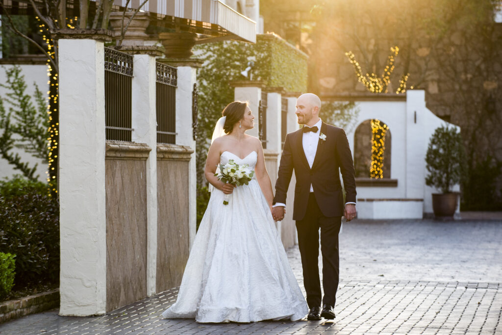 Bride and groom walking in courtyard at Bell tower on 34th

